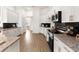 Bright kitchen featuring granite countertops, stainless steel appliances, dark backsplash, and wood flooring at 530 Sanctuary Blvd, Winter Haven, FL 33881