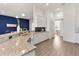 Open-concept kitchen with granite countertops, stainless steel sink, white cabinetry and an adjacent dining area at 530 Sanctuary Blvd, Winter Haven, FL 33881