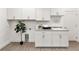 Bright laundry room features white cabinetry, granite countertops and a full-sized tree at 530 Sanctuary Blvd, Winter Haven, FL 33881