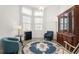 Bright living area featuring large windows, a blue decorative rug, and a classic wooden china cabinet at 530 Sanctuary Blvd, Winter Haven, FL 33881