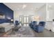 Open living room featuring a bright blue accent wall, wood-look flooring, and elegant furniture at 530 Sanctuary Blvd, Winter Haven, FL 33881