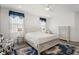 Comfortable main bedroom featuring a king bed, ceiling fan, and two windows with charming blue accents at 530 Sanctuary Blvd, Winter Haven, FL 33881