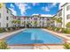 Resort-style pool with lounge chairs and surrounding landscaping at 5550 E Michigan St # 1128, Orlando, FL 32822