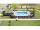 Community pool with patio, landscaping, and shaded seating area at 5626 Paddock Fence Ln, Apopka, FL 32712