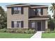 Two-story house with gray siding, brown roof, and landscaping at 5632 Paddock Fence Ln, Apopka, FL 32712