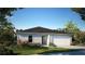 One-story home with gray siding, dark roof, and a two-car garage at 649 E Howry Ave, Deland, FL 32724
