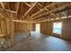 Interior view of a home under construction featuring wood studs, rafters and concrete floors at 649 E Howry Ave, Deland, FL 32724