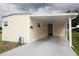 Side view of a one-story home with a carport, neutral siding, and well-maintained yard at 662 Sinclair Cir, Tavares, FL 32778