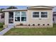Inviting front exterior with well-kept lawn, small garden, and charming facade, all under a clear blue sky at 662 Sinclair Cir, Tavares, FL 32778