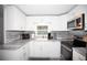 Updated kitchen featuring white cabinets, modern appliances, and gray countertops at 662 Sinclair Cir, Tavares, FL 32778