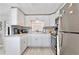 Modern kitchen with white cabinets, stainless steel appliances, and stylish gray backsplash at 662 Sinclair Cir, Tavares, FL 32778