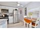 Bright kitchen featuring white cabinetry, stainless steel appliances, and a cozy dining area with a view at 662 Sinclair Cir, Tavares, FL 32778