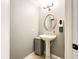 Powder room boasts a pedestal sink, updated lighting, and tile flooring at 848 Bucksaw Pl, Longwood, FL 32750