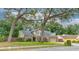Charming two-story home with manicured lawn, mature trees, and a covered front porch seating area at 848 Bucksaw Pl, Longwood, FL 32750