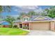 Inviting two-story home with manicured lawn, neutral color palette, and covered front porch seating area at 848 Bucksaw Pl, Longwood, FL 32750