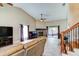 Open-concept living room with a fireplace, piano, and sliding doors to the outdoor patio space at 848 Bucksaw Pl, Longwood, FL 32750