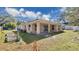 Backyard view of the home with the covered porch, grass, and foliage at 905 Ida St, Wildwood, FL 34785
