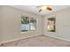Bright bedroom with neutral carpet, two windows, and a ceiling fan at 905 Ida St, Wildwood, FL 34785