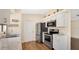 Bright kitchen featuring stainless steel appliances, white cabinets, and wood-look flooring at 905 Ida St, Wildwood, FL 34785