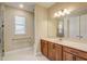 Bathroom featuring a vanity with granite countertop, a large mirror, and ample lighting at 9058 Sw 89Th Loop, Ocala, FL 34481