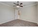 Bedroom features plush carpet, a ceiling fan, and access to the en-suite bathroom and walk-in closet at 9058 Sw 89Th Loop, Ocala, FL 34481