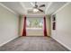 Comfortable bedroom with a tray ceiling, carpet, and ample natural light from a large window at 9058 Sw 89Th Loop, Ocala, FL 34481