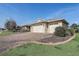 Well-maintained home featuring a three-car garage and a brick paved driveway at 9058 Sw 89Th Loop, Ocala, FL 34481