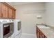 A well-equipped laundry room features modern washer and dryer, ample cabinetry, and a convenient utility sink at 9058 Sw 89Th Loop, Ocala, FL 34481