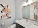 Stylish bathroom featuring a modern vanity, decorative artwork, and a comfortable toilet at 1015 Jack Nicklaus Ct, Kissimmee, FL 34747