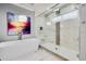 Stunning bathroom showcasing a modern tub and walk-in shower with floor-to-ceiling marble-look tile at 1015 Jack Nicklaus Ct, Kissimmee, FL 34747