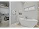 Modern bathroom showcasing a freestanding tub, stylish lighting, and a view into the bedroom at 1015 Jack Nicklaus Ct, Kissimmee, FL 34747