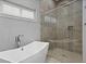 Spa-like bathroom featuring a soaking tub and a glass-enclosed shower with tiled accents at 1015 Jack Nicklaus Ct, Kissimmee, FL 34747