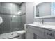Modern bathroom featuring a glass-enclosed shower with sleek tile and a stylish vanity with white countertop at 1015 Jack Nicklaus Ct, Kissimmee, FL 34747