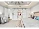 Beautiful bedroom featuring barn doors, a tray ceiling with a fan, and a view into the bathroom at 1015 Jack Nicklaus Ct, Kissimmee, FL 34747