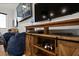 Relaxing game room with dark wood cabinets and shelving underneath a large television screen at 1015 Jack Nicklaus Ct, Kissimmee, FL 34747
