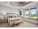 Bright bedroom with a large bed, ceiling fan, and window seat overlooking the outdoor community at 1015 Jack Nicklaus Ct, Kissimmee, FL 34747