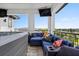 Stylish covered patio offers a relaxing space with a jacuzzi and comfortable blue couch at 1015 Jack Nicklaus Ct, Kissimmee, FL 34747