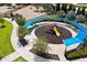 Aerial view of a playground with colorful equipment and shaded seating surrounded by trees at 1015 Jack Nicklaus Ct, Kissimmee, FL 34747