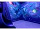 Playroom with a slide and space themed mural for a fun and immersive experience at 1015 Jack Nicklaus Ct, Kissimmee, FL 34747
