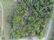 Overhead aerial view of a home nestled among trees and close to a road at 1050 Bob White Trl, Chuluota, FL 32766