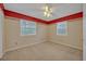 Well-lit bedroom featuring carpeted floors and two windows overlooking the lush outdoors at 1050 Bob White Trl, Chuluota, FL 32766