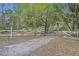 Long gravel driveway leading to a gated property with mature trees at 1050 Bob White Trl, Chuluota, FL 32766