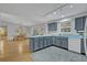 Open kitchen with blue cabinets and updated appliances, blending seamlessly with the dining area at 1050 Bob White Trl, Chuluota, FL 32766