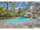 Inviting in-ground pool surrounded by a wooden deck and lush landscaping at 1050 Bob White Trl, Chuluota, FL 32766