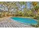 Inviting in-ground pool surrounded by a wooden deck and lush landscaping at 1050 Bob White Trl, Chuluota, FL 32766