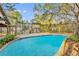 Inviting in-ground pool surrounded by a tiled deck and lush landscaping at 1050 Bob White Trl, Chuluota, FL 32766