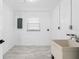 Spacious basement laundry room with a large sink, tiled floors, and a window for natural light at 1113 Leeward Dr, Deltona, FL 32738