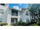 Condominium complex exterior featuring upper level balcony, lush bushes, and siding at 11574 Westwood Blvd # 1122, Orlando, FL 32821