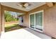 Covered back patio featuring a ceiling fan and sliding glass doors, blending indoor/outdoor living at 12 Pecan Drive Loop, Ocala, FL 34472