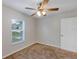 Bright bedroom with a ceiling fan, window and carpeted flooring at 12 Pecan Drive Loop, Ocala, FL 34472